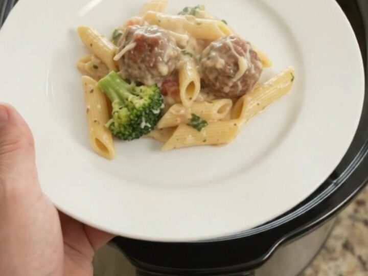 Slow cooker full of creamy mozzarella meatball Alfredo penne with broccoli