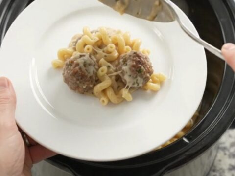 Creamy Crockpot meatball cavatappi with melted cheese and meatballs in a slow cooker