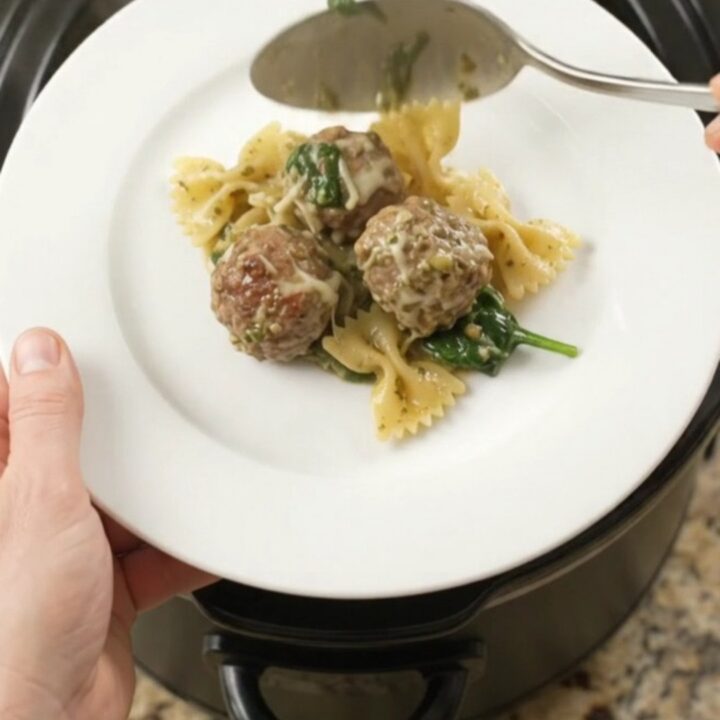 Slow cooker filled with creamy pasta, meatballs, and melted cheese