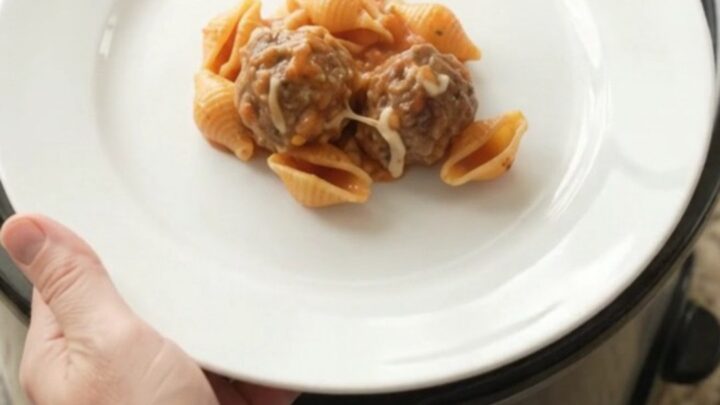 Slow cooker full of creamy meatball pasta shells with melted cheese