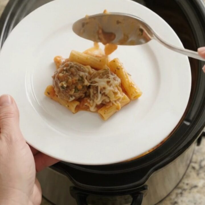 A slow cooker filled with bubbling mozzarella meatball baked ziti