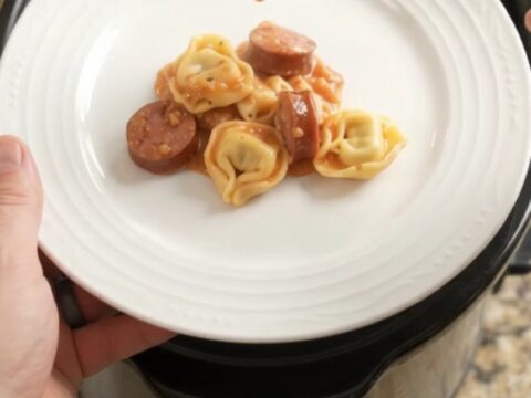 Slow cooker filled with creamy kielbasa tortellini and melted mozzarella