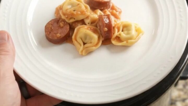 Slow cooker filled with creamy kielbasa tortellini and melted mozzarella