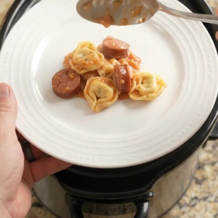 Slow cooker filled with creamy kielbasa tortellini and melted mozzarella