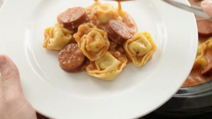 Slow cooker filled with creamy kielbasa tortellini, topped with melted provolone and ricotta.