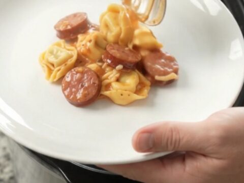 Slow cooker filled with creamy Boursin kielbasa tortellini, topped with melted fontina cheese