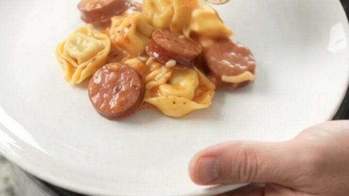 Slow cooker filled with creamy Boursin kielbasa tortellini, topped with melted fontina cheese