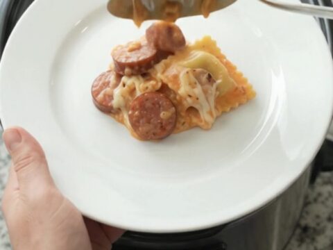 Slow cooker filled with creamy vodka sauce, ravioli, and kielbasa, topped with melted mozzarella.