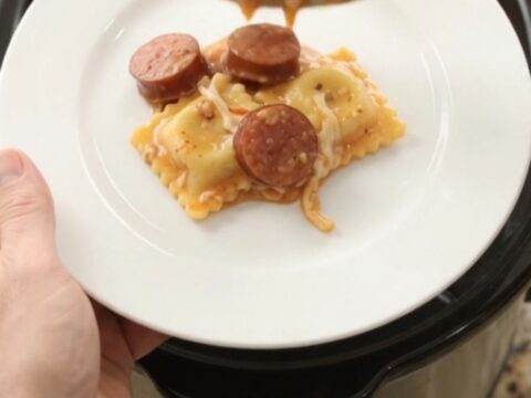 Bubbling Crockpot of kielbasa and ravioli in creamy vodka sauce topped with melted provolone.