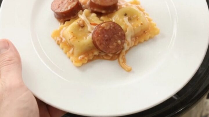 Bubbling Crockpot of kielbasa and ravioli in creamy vodka sauce topped with melted provolone.