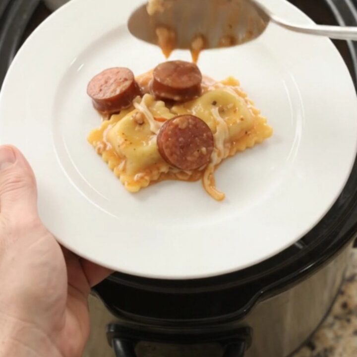 Bubbling Crockpot of kielbasa and ravioli in creamy vodka sauce topped with melted provolone.