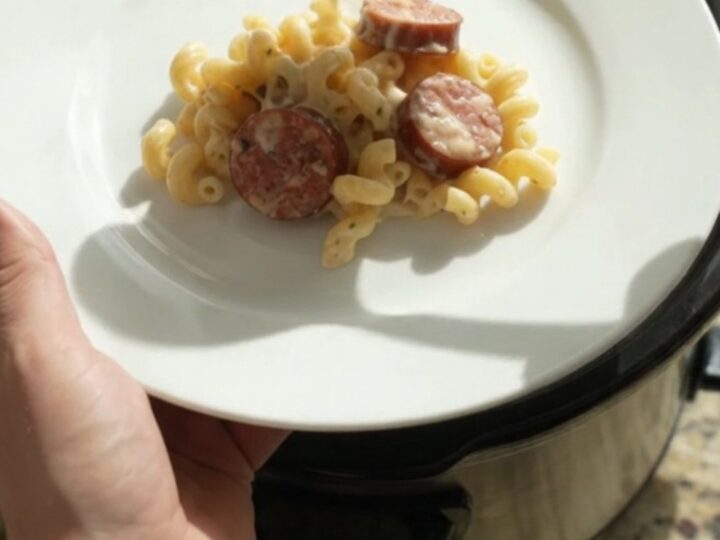 Creamy cavatappi pasta with smoked kielbasa in a slow cooker, topped with melted cheese and Parmesan