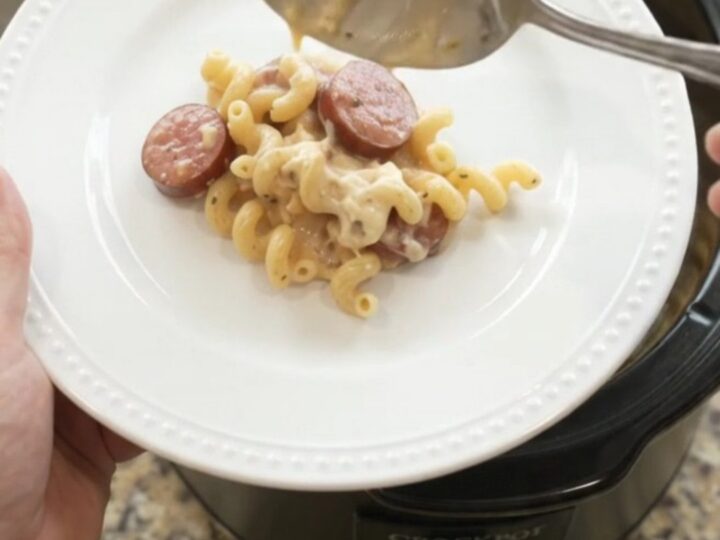 Slow cooker full of creamy cavatappi pasta with kielbasa and melted provolone