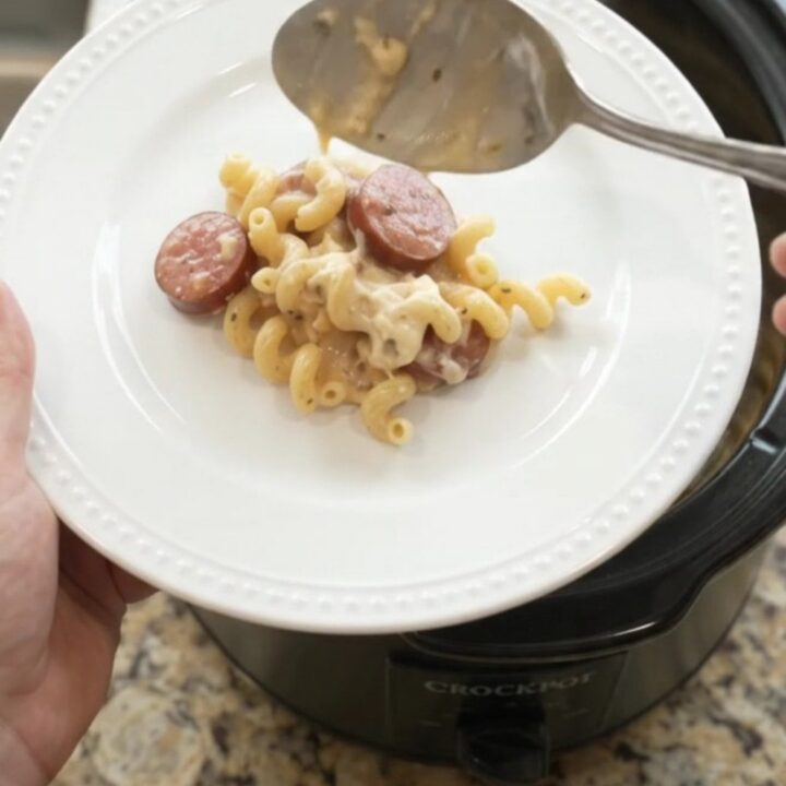 Slow cooker full of creamy cavatappi pasta with kielbasa and melted provolone