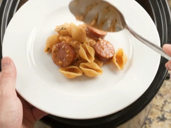 Bubbling Crockpot casserole with smoked kielbasa, pasta shells, and melted provolone cheese