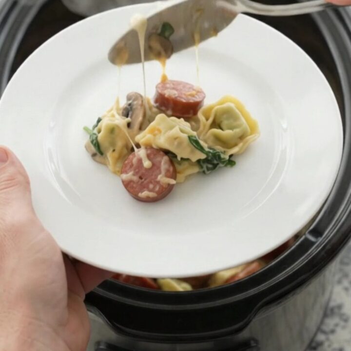 Slow cooker filled with creamy kielbasa tortellini, topped with melted cheese and golden crust.