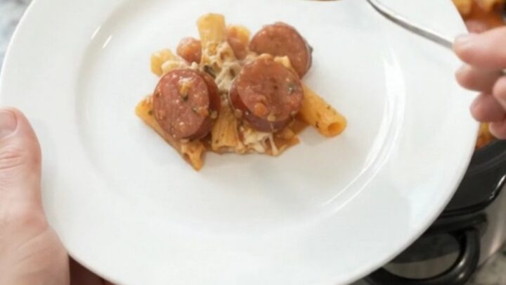 A bubbling Crockpot full of Provolone Kielbasa Baked Ziti, with melted cheese and sausage coins visible.