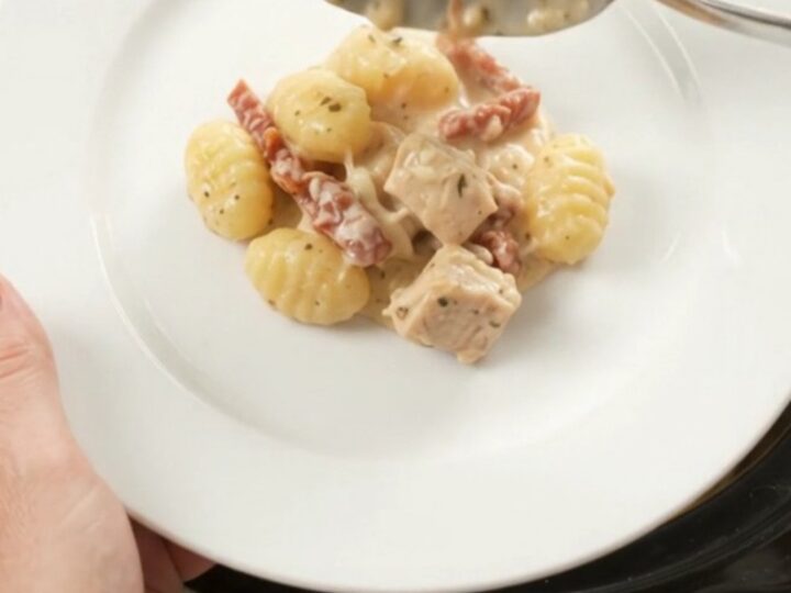 Creamy Crockpot chicken Tuscan gnocchi with melted mozzarella in a slow cooker
