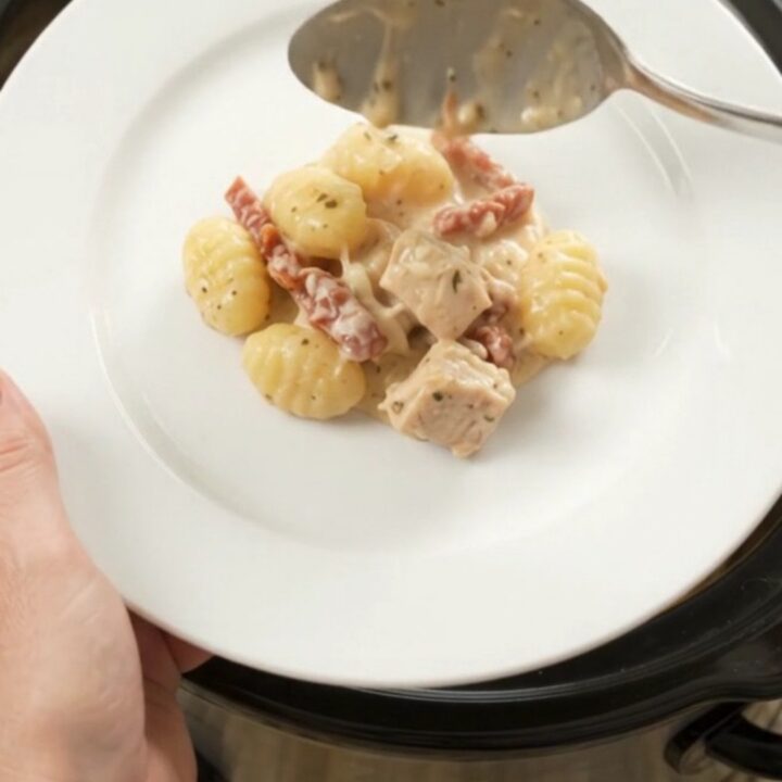 Creamy Crockpot chicken Tuscan gnocchi with melted mozzarella in a slow cooker