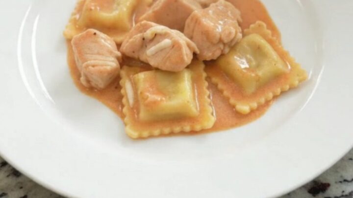 Slow cooker filled with creamy chicken vodka ravioli topped with melted mozzarella.