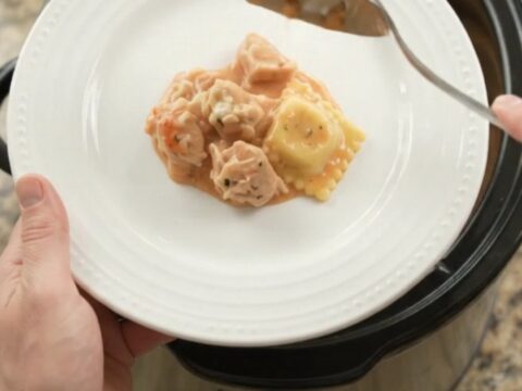 Bubbling slow cooker full of chicken vodka ravioli with melted provolone and ricotta