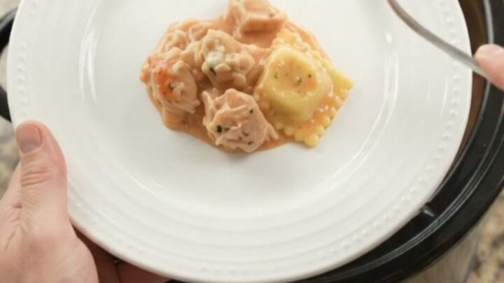 Bubbling slow cooker full of chicken vodka ravioli with melted provolone and ricotta