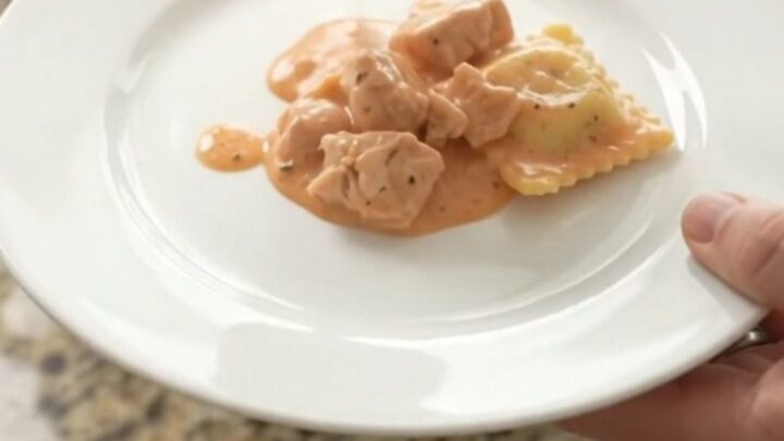 Slow cooker filled with creamy Boursin chicken vodka ravioli, topped with melted fontina and fresh herbs