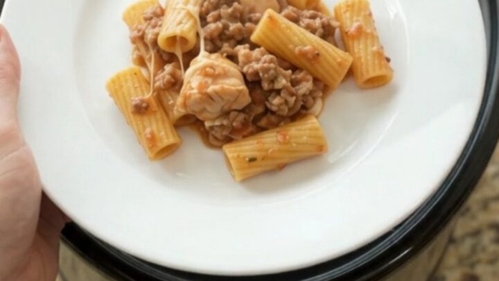 Slow cooker chicken rigatoni with melted provolone and ricotta in a black crockpot