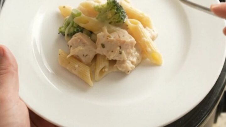 Crockpot Chicken Alfredo Penne with melted cheese and tender pasta, served in a bowl