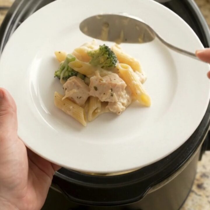 Crockpot Chicken Alfredo Penne with melted cheese and tender pasta, served in a bowl