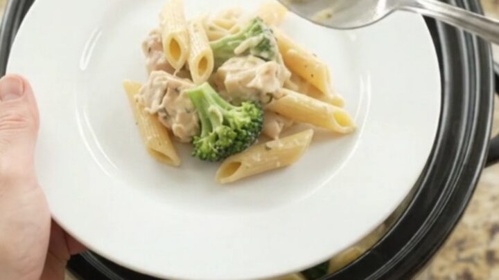Boursin Chicken Alfredo Penne in a slow cooker with melted cheese and steam rising