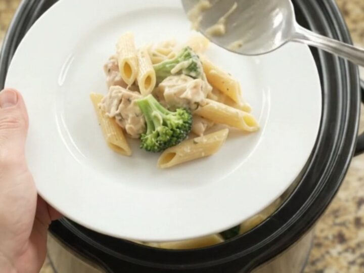 Boursin Chicken Alfredo Penne in a slow cooker with melted cheese and steam rising
