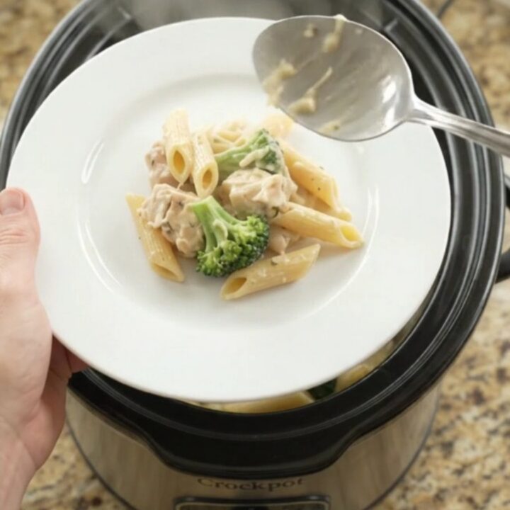 Boursin Chicken Alfredo Penne in a slow cooker with melted cheese and steam rising