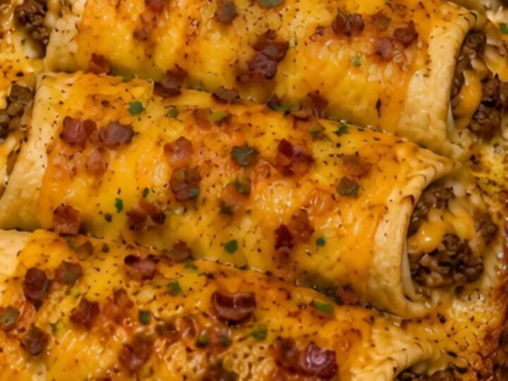 A golden-brown bacon cheeseburger crescent bake in a glass dish, garnished with fresh parsley.