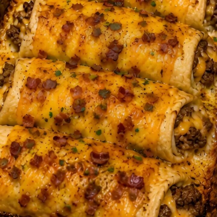 A golden-brown bacon cheeseburger crescent bake in a glass dish, garnished with fresh parsley.