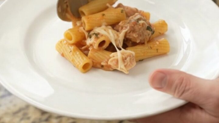 Slow cooker filled with bubbling Parmesan chicken baked ziti, topped with melted cheese and golden crust.