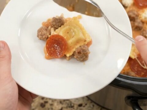 Bubbling slow cooker pasta with pepperoni, sausage, ravioli, and melted provolone