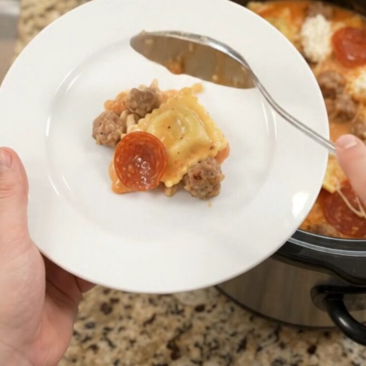 Bubbling slow cooker pasta with pepperoni, sausage, ravioli, and melted provolone