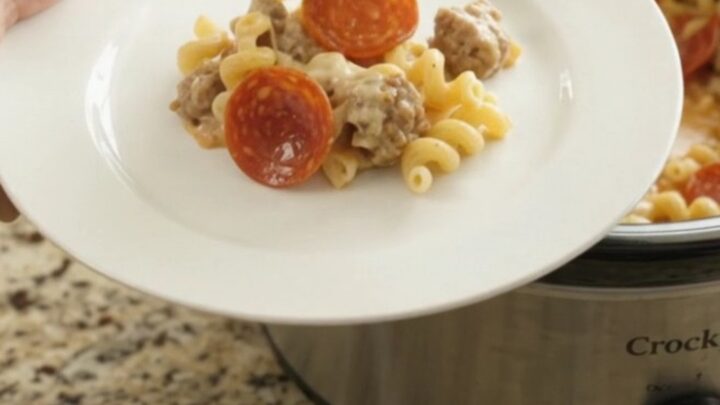A creamy slow cooker cavatappi with pepperoni and sausage, topped with melted cheese and Parmesan.