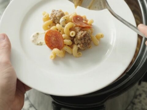 Creamy Crockpot cavatappi with pepperoni, sausage, and melted fontina in a slow cooker.