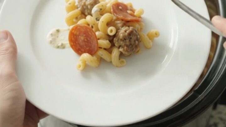 Creamy Crockpot cavatappi with pepperoni, sausage, and melted fontina in a slow cooker.
