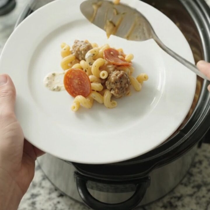 Creamy Crockpot cavatappi with pepperoni, sausage, and melted fontina in a slow cooker.