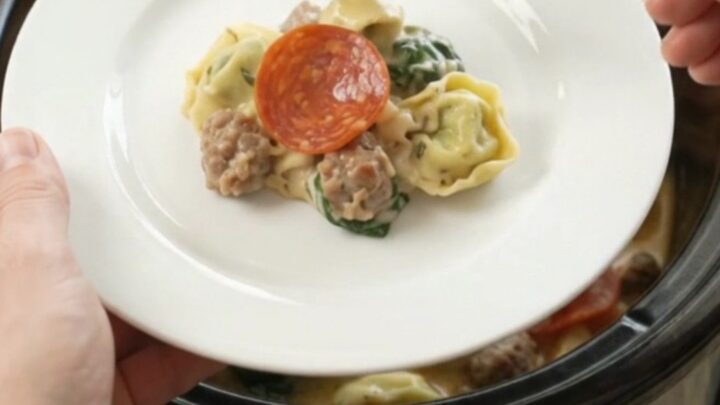 Crockpot Boursin pepperoni sausage tortellini with melted cheese and steam rising