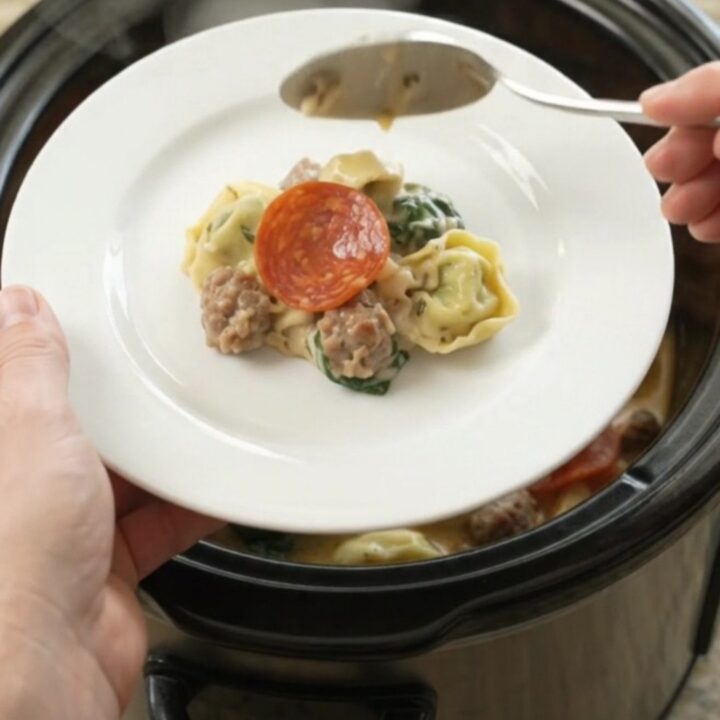 Crockpot Boursin pepperoni sausage tortellini with melted cheese and steam rising