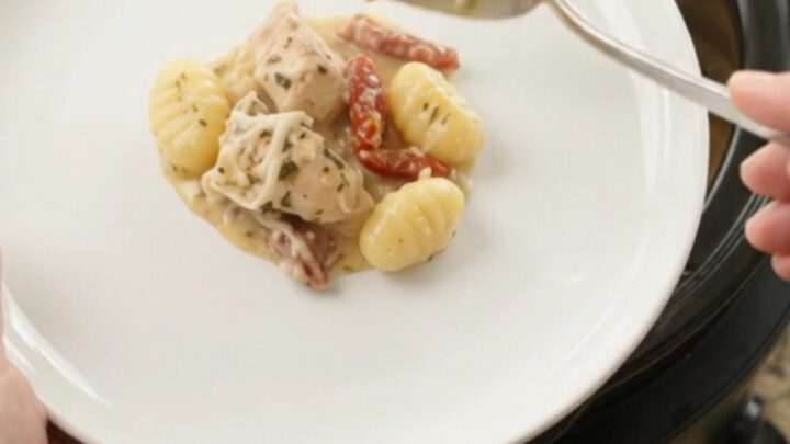 Creamy slow cooker chicken gnocchi with melted Boursin and fontina, bubbling in a black Crockpot