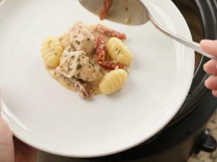 Creamy slow cooker chicken gnocchi with melted Boursin and fontina, bubbling in a black Crockpot