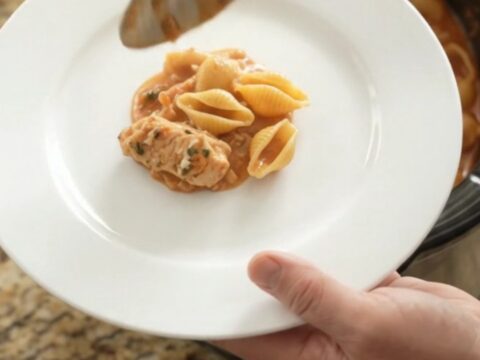 Bubbling slow cooker pasta bake with golden cheese crust and creamy red pepper sauce
