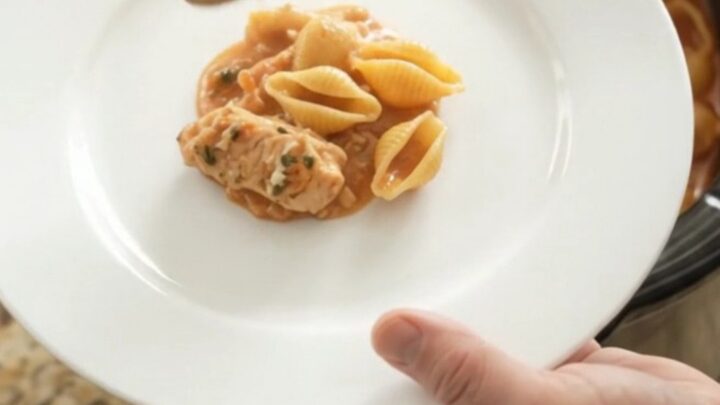 Bubbling slow cooker pasta bake with golden cheese crust and creamy red pepper sauce