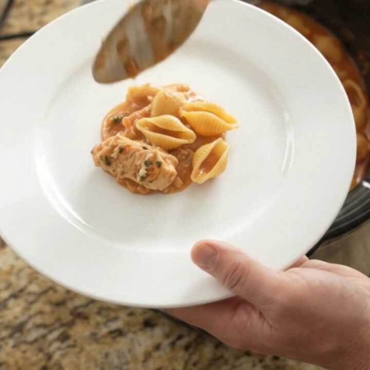 Bubbling slow cooker pasta bake with golden cheese crust and creamy red pepper sauce