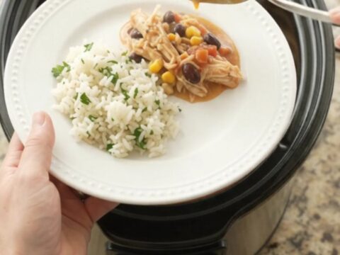 Shredded fiesta chicken in creamy cheese sauce with black beans and corn in a slow cooker